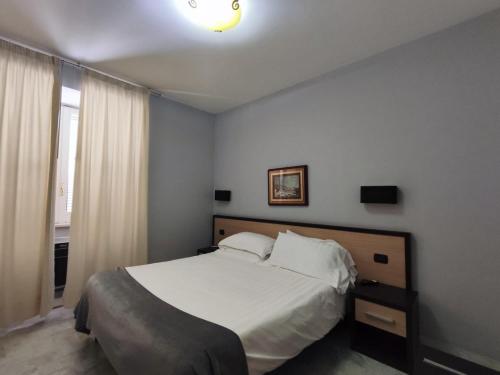 a bedroom with a white bed and a window at Hotel Quadrifoglio in Pontecagnano