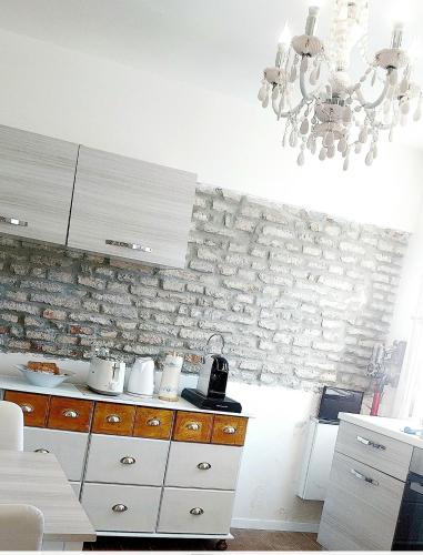 a kitchen with white cabinets and a stone wall at Burano Cà Comare in Burano