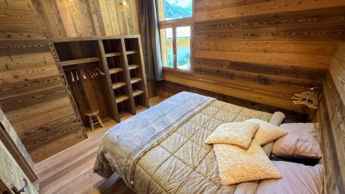 a bedroom with a bed in a log cabin at Un Brin Cosy in Névache