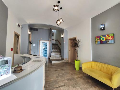 a bathroom with a sink and a yellow bench at Hotel Quadrifoglio in Pontecagnano