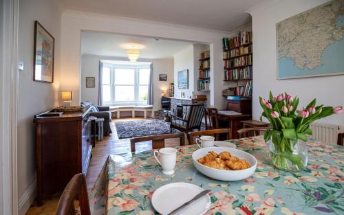 a living room with a table with a bowl of food at 3 Avonside, Bantham - period property with stunning sea views! in Bantham