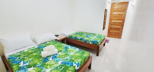 PoocにあるHey Mojo Guest Houseのベッド2台と階段の吹き抜けが備わる客室です。