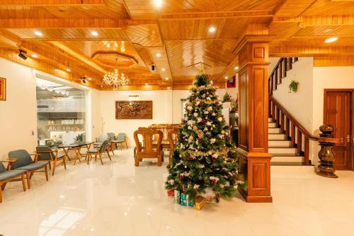 a christmas tree in the middle of a lobby at Lê Mùi Hotel - Apartment in Da Thien