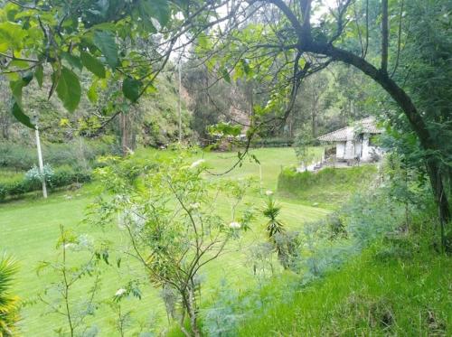 a green field with a house in the distance at Hostería el Socavón in Guaranda