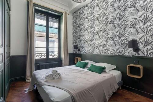 une chambre avec un grand lit avec des oreillers verts dans l'établissement Le Méritant Jacobins Center of Lyon, à Lyon