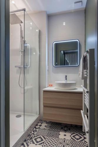 une salle de bain avec un lavabo et une douche avec un miroir dans l'établissement Le Méritant Jacobins Center of Lyon, à Lyon