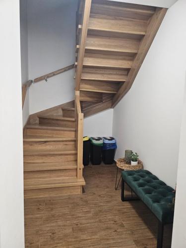 a living room with stairs and a green couch at "Hel" Wieniec Zdrój in Włocławek