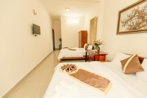 a hotel room with two beds and a television at Lê Mùi Hotel - Apartment in Da Thien