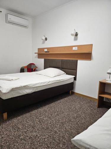 a bedroom with two beds and a shelf on the wall at "Hel" Wieniec Zdrój in Włocławek