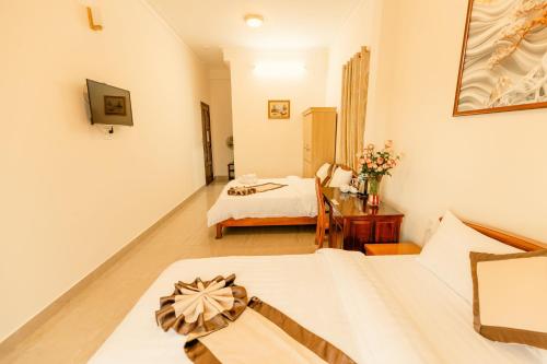 a living room with a bed and a room with a bed sqor at Lê Mùi Hotel - Apartment in Da Thien