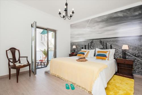 a bedroom with a bed with a painting on the wall at Beachouse - Surf, Bed & Breakfast in Ericeira