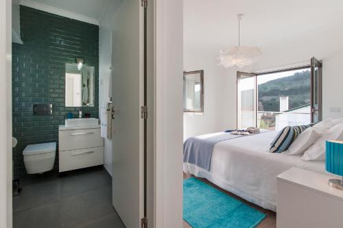 a bedroom with a bed and a sink and a mirror at Beachouse - Surf, Bed & Breakfast in Ericeira