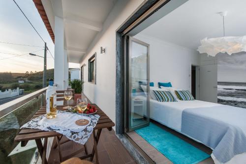 a bedroom with a bed and a table on a balcony at Beachouse - Surf, Bed & Breakfast in Ericeira