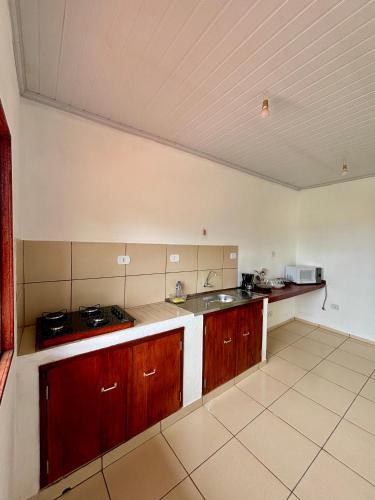 a large kitchen with wooden cabinets and a sink at Pouso da Celeste - Trindade in Trindade