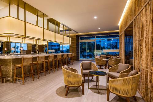 a bar in a restaurant with chairs and tables at Santa Marta Marriott Resort Playa Dormida in Santa Marta