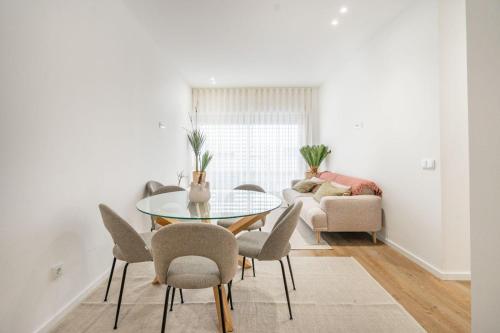 a dining room with a glass table and chairs at GO UP - Apartamento no Centro de Guimarães in Guimarães