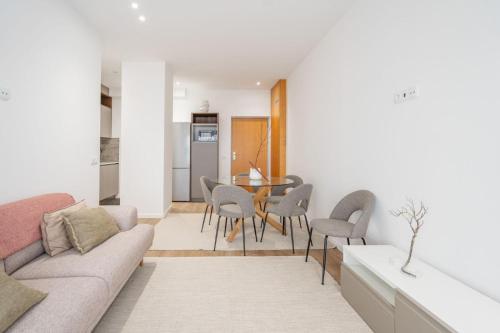a living room with a couch and a table and chairs at GO UP - Apartamento no Centro de Guimarães in Guimarães