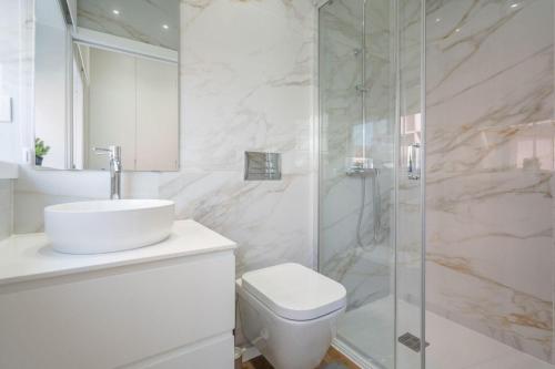 a bathroom with a toilet and a sink and a shower at GO UP - Apartamento no Centro de Guimarães in Guimarães