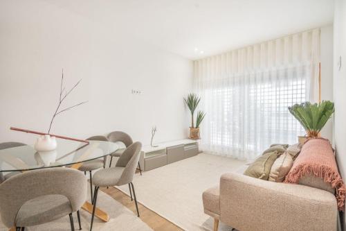 a living room with a glass table and chairs at GO UP - Apartamento no Centro de Guimarães in Guimarães