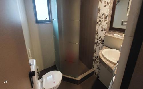a bathroom with a shower and a toilet and a sink at Lytton Hotel in Kolkata