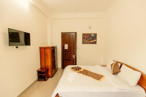 a bedroom with a bed and a flat screen tv at Lê Mùi Hotel - Apartment in Da Thien