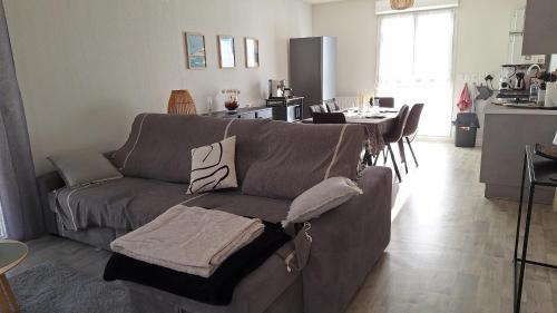 un salon avec un canapé et une cuisine avec une table dans l'établissement Paisible appartement central avec terrasse, à La Teste-de-Buch