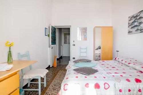 sypialnia z łóżkiem, biurkiem, stołem i krzesłami w obiekcie B&B Blue Home w Genui