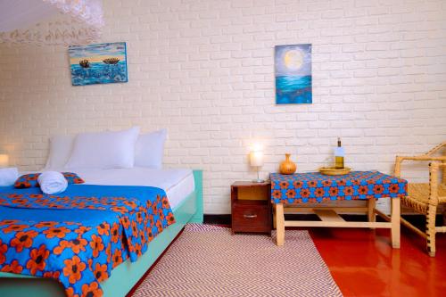 a bedroom with two beds and a table in it at Isange Paradise Resort in Ruhengeri