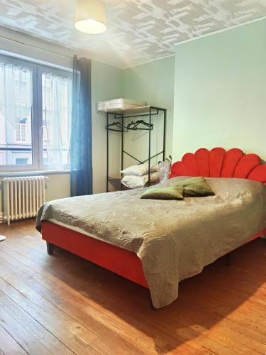 - une chambre avec un grand lit à tête rouge dans l'établissement Appartement Boulogne - Hyper centre, à Boulogne-sur-Mer