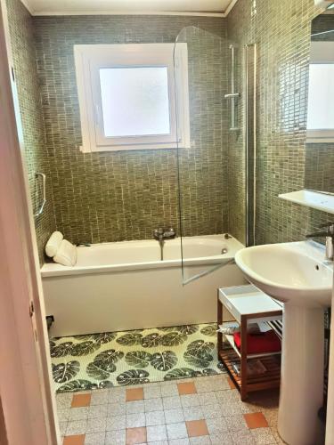 une salle de bain avec une baignoire et un lavabo dans l'établissement Appartement Boulogne - Hyper centre, à Boulogne-sur-Mer