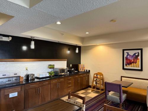 a kitchen with wooden cabinets and a counter top at SureStay by Best Western Forsyth Decatur in Forsyth