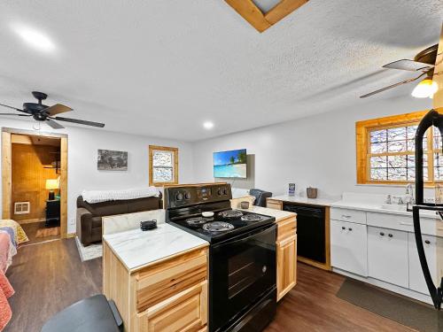a kitchen with a stove and a living room at Bearly Behaving Creekside in Maggie Valley