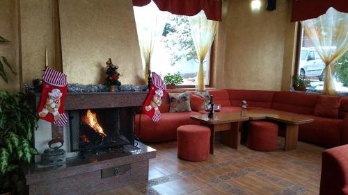 a living room with a couch and a fireplace at Family Hotel Emaly 1 in Bankya