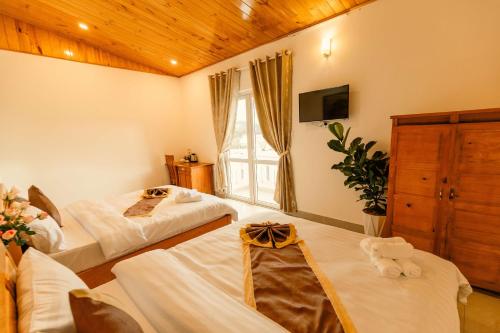 a hotel room with two beds and a window at Lê Mùi Hotel - Apartment in Da Thien