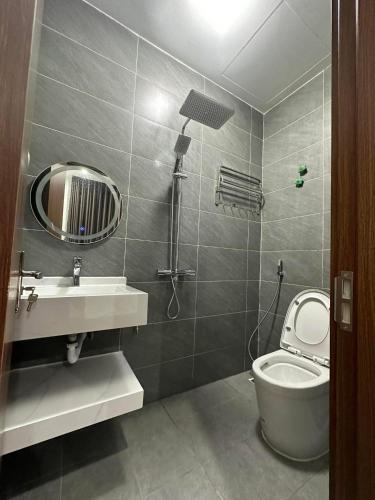 a bathroom with a toilet and a sink and a mirror at Hotel Lâm Anh 35 in Binh Quân
