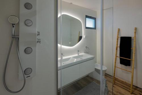 ein weißes Badezimmer mit Waschbecken und Spiegel in der Unterkunft Peace Haven III in Câmara de Lobos