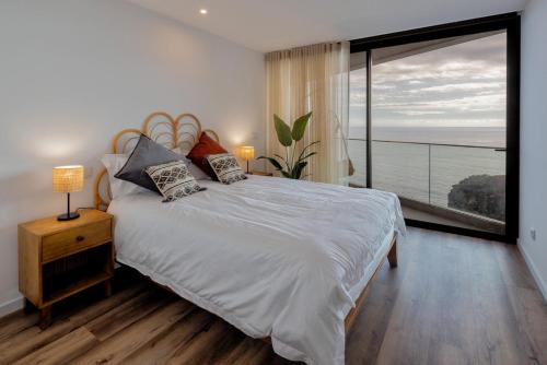 ein Schlafzimmer mit einem großen Bett und einem großen Fenster in der Unterkunft Peace Haven III in Câmara de Lobos