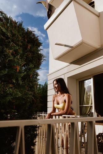a woman in a bikini sitting on a balcony at Villa Orso Grigio in Ronzone