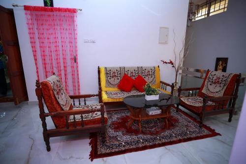 a living room with three chairs and a table at LA CASA THE HOMESTAY in Trivandrum
