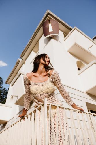 a woman standing on a fence in front of a building at Villa Orso Grigio in Ronzone