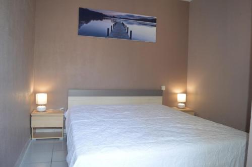 - une chambre avec un lit blanc et 2 tables de chevet avec des lampes dans l'établissement Appartement 3 pièces 6 personnes SC540-A156, à Saint Cyprien Plage