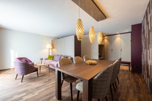 a dining room and living room with a table and chairs at Hotel Allegra 3 Stern Superior in Pontresina