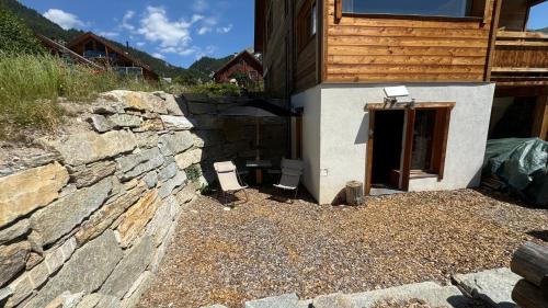 a stone wall next to a building with a window at Un Brin Cosy in Névache