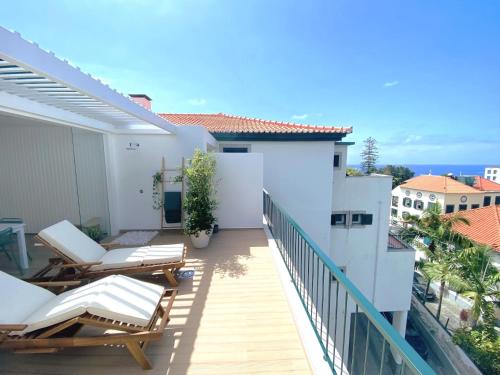 a balcony with chairs and a view of the ocean at Madeira Precious Penthouse in Funchal