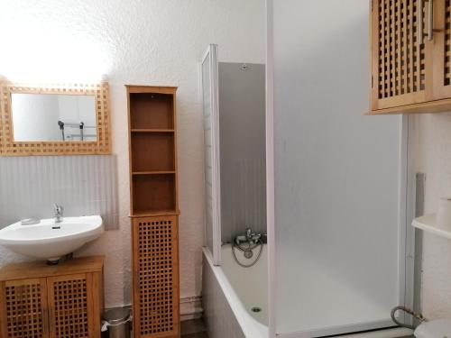une salle de bain blanche avec un lavabo et une douche dans l'établissement LaGodille Pra Loup 1500, à Pra-Loup