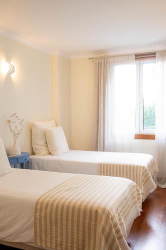 a hotel room with two beds and a window at Madeira Precious Penthouse in Funchal