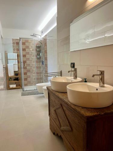 a bathroom with two sinks and a shower at Appartamenti La Rocia in Rocca Pietore