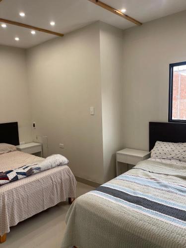 a bedroom with two beds and a window at Casa Apartament Paseo Del Mar in Chimbote