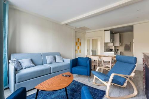 un salon avec un canapé bleu et des chaises dans l'établissement Hamac Suites - Suite Arloing - 6 people, à Lyon