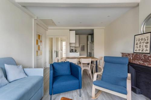 un salon avec des chaises bleues et une table dans l'établissement Hamac Suites - Suite Arloing - 6 people, à Lyon